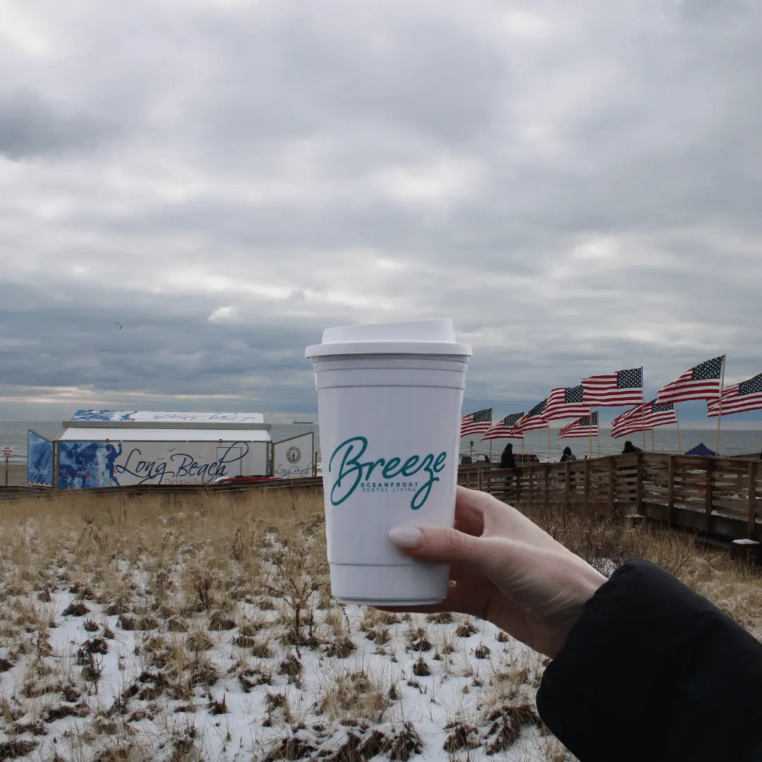 image of hand holding a coffee cup with The Breeze logo on the Boardwalk at Long Beach NY Polar Plunge 2025